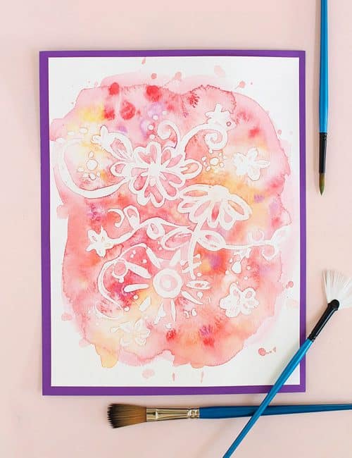 rubber cement watercolor resist art surrounded by paint brushes