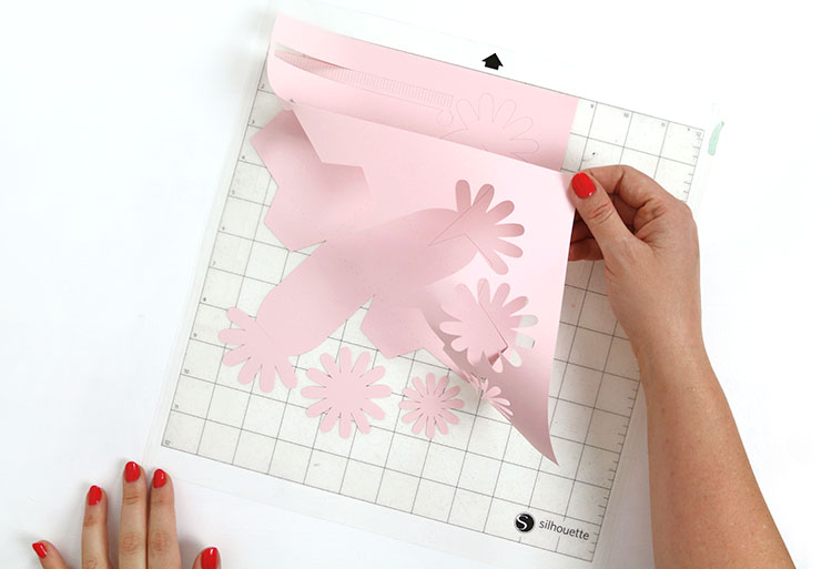 Peeling cut unassembled paper flower box off of Silhouette cutting mat