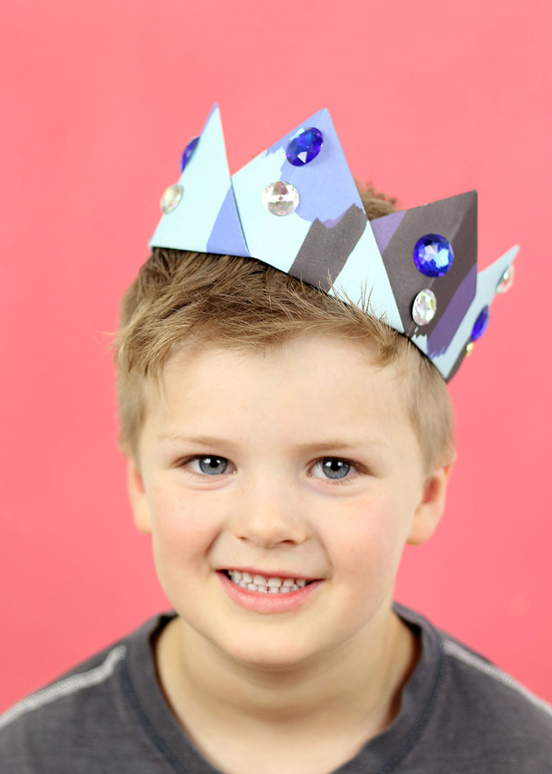 boy wearing blue origami crown
