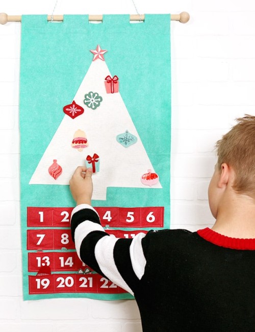child putting ornament on DIY felt Christmas tree advent calendar