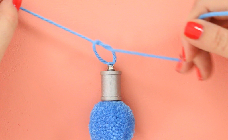 tying knot over silver bead and silver spool