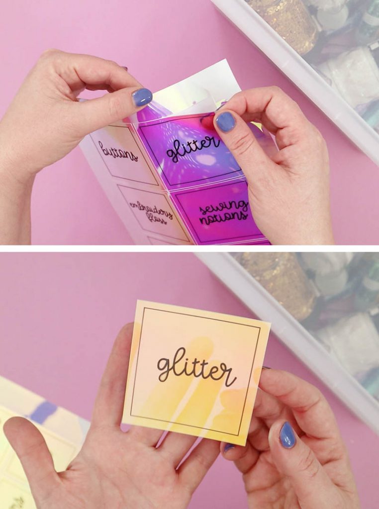 a hand peeling off one sticker that reads "glitter" from a sheet of sketched and cut craft room labels on iridescent sticker paper