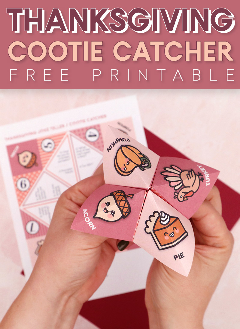 Two hands holding a pink,  orange, and burgundy colored cootie catcher/joke teller with drawings of a pumpkin, turkey, acorn, and piece of pie on it.