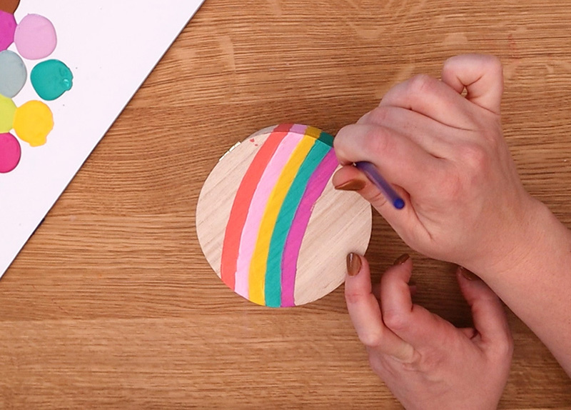 Painting last colored stripe on the top of the box.