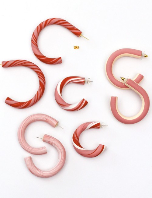 handmade pink clay hoop earrings lay on white background