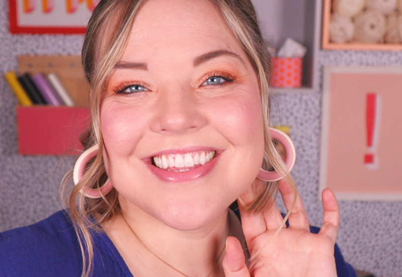 smiling woman wearing clay hoop earrings