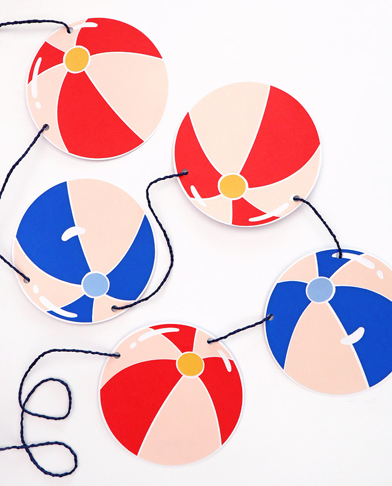 colorful paper beach balls strung on dark blue twine to make a beach ball paper garland